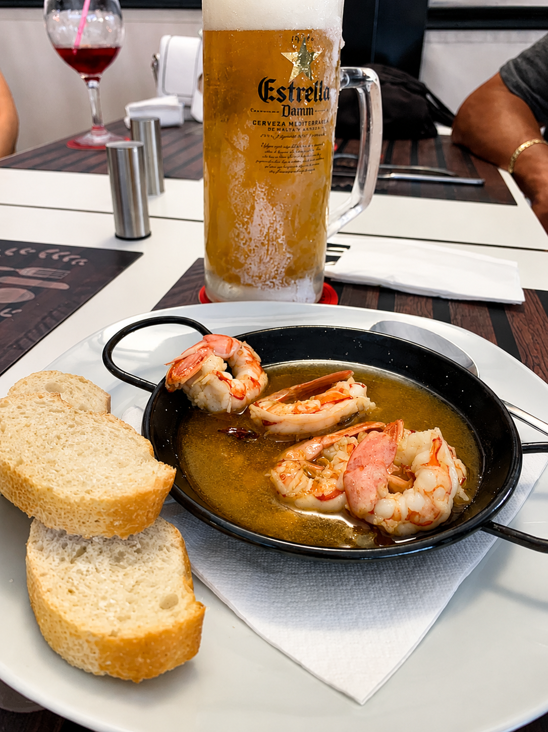 Gambas al ajillo served with fresh bread and Estrella Damm beer